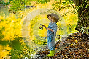 Weekend. A fishing boy is fishing in a pond. A handsome boy and his hobbies. Fishing rod. Camping with children. Fish