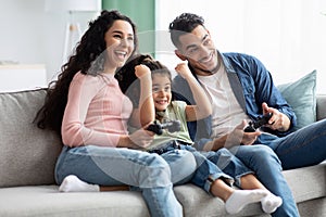 Weekend Leisure. Arab Family Of Three Playing Video Games In Living Room