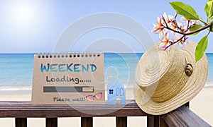 Weekend loading calendar on wooden fence with tropical beach background