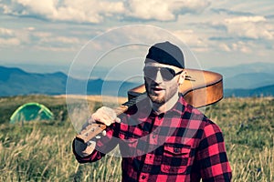 Weekend in nature, camping. Guy with tired face and lonely at picnic. Man hipster hiker in forest. Hiking and vacation