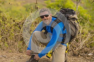 Weekend outdoors - young happy and attractive hiker man with backpack walking around in the wood enjoying hiking activity and