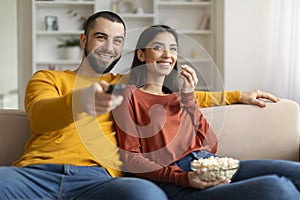 Weekend Pastime. Happy Caucasian Couple Watching Tv And Eating Popcorn At Home