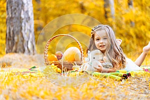 Weekend at picnic. Lovely caucasian girl on grass meadow with basket full of fruits. Female child kid on nature sit on
