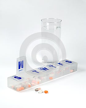 Weekly pill box with glass of water photo