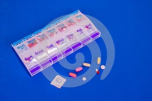 Weekly Pills In Pill Box On Smooth Blue Background