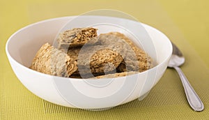 Weet-Bix in White Bowl with Spoon.