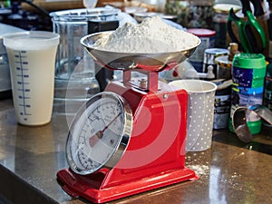 Weighs flour on manual pie scale in home kitchen