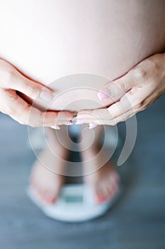 Weight gain during pregnancy with pregnant woman stepping on scale