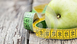 Weight loss, diet concept - green apple with tape measure, web banner