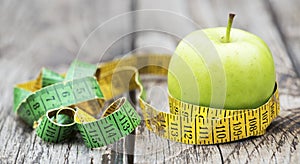 Weight loss, diet, diabetes concept, green apple with tape measure