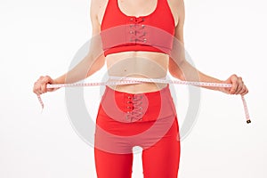 Weight loss, slim body, healthy lifestyle concept. Fit fitness girl measuring her waistline with measure tape