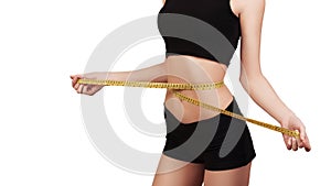 Weight loss, slim body, healthy lifestyle concept. Fitness girl measuring her waistline with measure tape, isolated on white. Copy