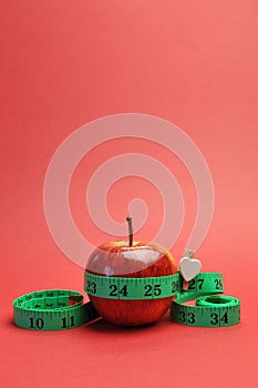 Weight loss slimming diet concept apple & tapemeasure - vertical.