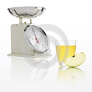 Weight scale with apple juice glass isolated on white background