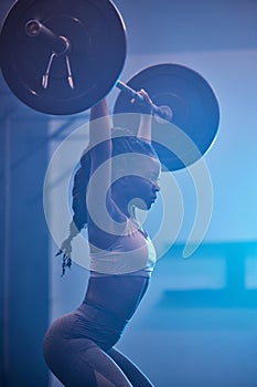 Weightlifting focus, motivation and fitness workout mindset of woman lifting weights at a gym. Female from Kenya working