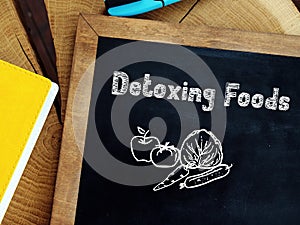 Weightloss concept meaning Detoxing Foods with inscription on the piece of paper photo