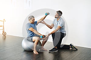 Weights, physiotherapy and help with doctor and old man for rehabilitation, training or stretching. Healthcare, wellness