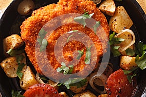 Weiner schnitzel, fried potatoes in a pan closeup. horizontal to