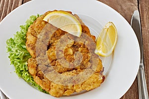 Weiner schnitzel with green salad and lemon