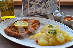 Weiner schnitzel with potato salad on a wooden background