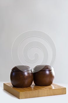 Weiqi wood board with bowls on top isolated on white with copy space