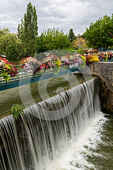 The weir of Kir lake with beautiful flowers on a cloudy day in summer