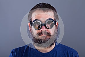 Weird guy with matted hair and large beard wearing broken welding goggles photo