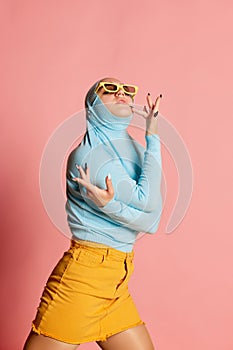 Weird people concept. Creative portrait of young girl in avant-garde fashion style outfit posing isolated over pink