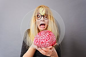 Weird woman holding brain having idea