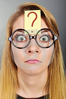 Weirdo nerd woman having question mark on forehead