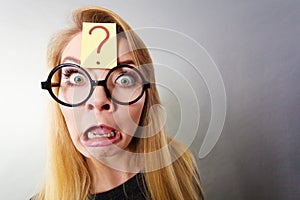 Weirdo nerd woman having question mark on forehead