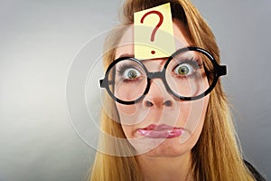 Weirdo nerd woman having question mark on forehead