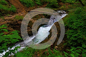 Weissbachschlucht a gorge with a blue mountain stream and many waterfalls forest a hiking trail plants and rocks