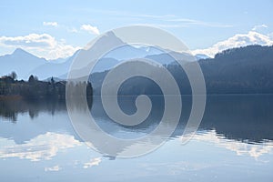 Weissensee, idyllic lake in dusty morning light front of the blue mountains of the bavarian alps near fÃ¼ssen in the allgÃ¤u,