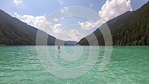 Weissensee - A man stand up paddling through the crystal clear lake