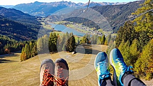 Weissensee - Two pairs of hiking shoes on the slope with the view on a distant lake