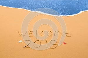Welcome 2019 written in the sand
