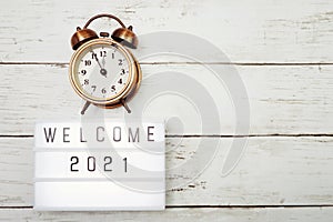 Welcome 2021 text in light box with space copy on wooden background