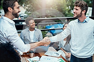 Welcome aboard the best business. businesspeople shaking hands during a meeting at a cafe.