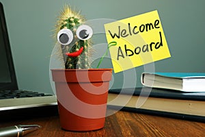 Welcome aboard concept. Funny cactus on workplace in the office photo