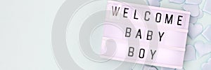 Welcome baby boy. Banner with lightbox with letters and blue confetti.