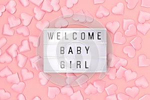 Welcome baby girl. Lightbox with letters and confetti in a heart shape.