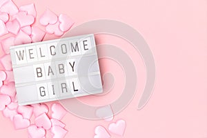 Welcome baby girl. Lightbox with letters and confetti in a heart shape.