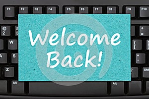 Welcome Back message on a greeting card on black keyboard