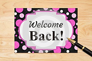 Welcome Back message on a greeting card on wood desk