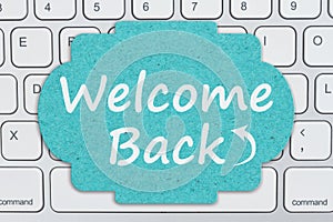 Welcome Back message on a sign on gray keyboard