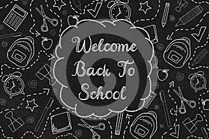 Welcome back to school with doodles on a black chalkboard. Textured background.