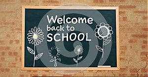 Welcome back to school text and flowers on blackboard