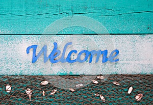 Welcome beach sign with shells and sand