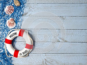 Welcome on Board - lifebuoy with text and shells on wooden background